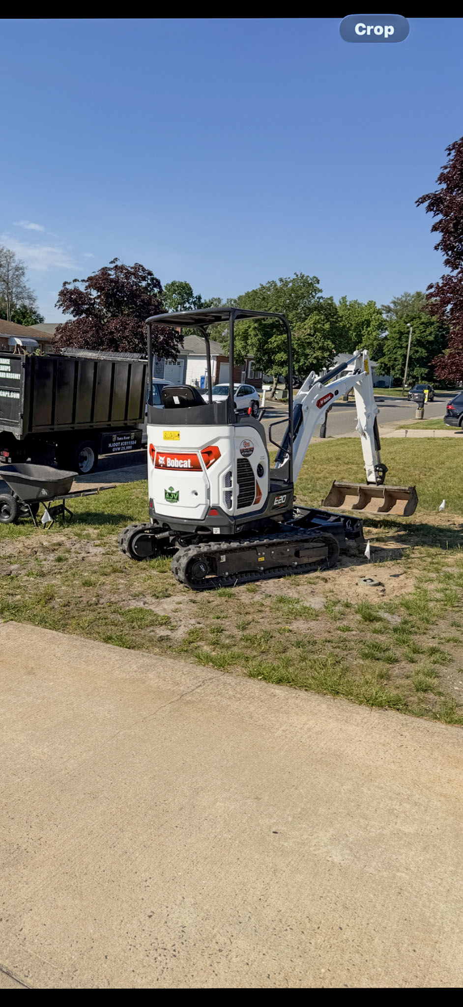 AJV Bobcat excavator and work truck at a residential site