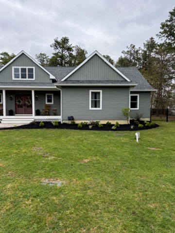 Front-yard landscape bed with foundation shrubs and fresh black mulch